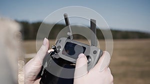 Women`s hands holding a remote control drone