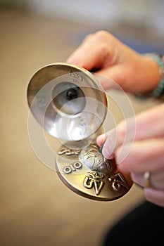 Women`s hands holding Tibetan Tingsha Cymbals for Relaxation, Meditation, and Yoga