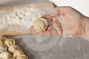 Women`s hands make dumplings