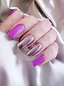 Women`s hands manicure silk fabric bright stylish glamour