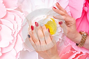 Women `s hands. Multi- colored manicure using red, black, white colors