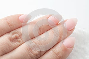 Women`s hands with perfect Nude manicure. Nail Polish is a natural pale pink shade.