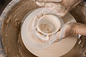 Women`s hands and potter`s wheel