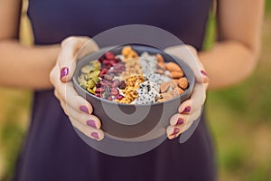 Women`s hands are preparing a smoothie bowl