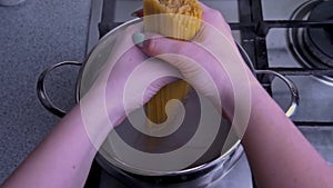 Women's Hands Put Spaghetti in a Pot of Boiling Water in Slow Mo