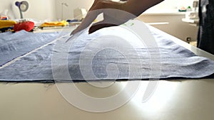 Women`s hands of seamstresses make markings on the pattern using a special chalk and ruler. Sewing workshop, toy factory