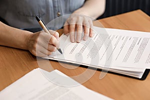 Women& x27;s hands sign business documents, contracts, papers in close-up.