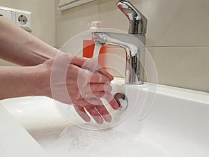 Women`s hands with soap sink