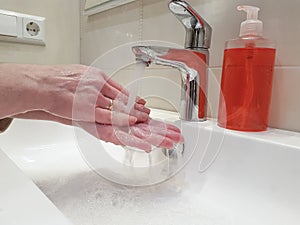 Women`s hands with soap sink splash