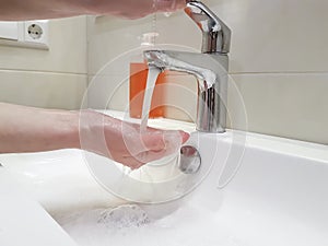 Women`s hands with soap sink splash personal