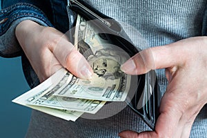 Women`s hands take money dollars out of their wallets