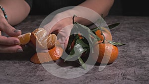 women's hands take a purified tangerine