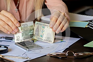 Women`s hands tear ten rubles at a table with reports, default in Russia due to sanctions, collapse of the ruble