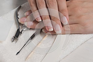 Women`s hands on a towel. Manicure. Manicure tools, nail Polish. Home nail care, SPA, beauty. Long natural nails. Beauty salon