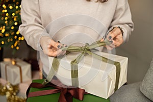 Women's hands unpack New Year's gifts