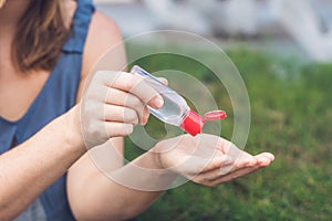 Women`s hands using wash hand sanitizer gel pump dispenser