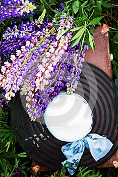 Women`s hat with beautiful lupine flowers lying on the grass, fashion