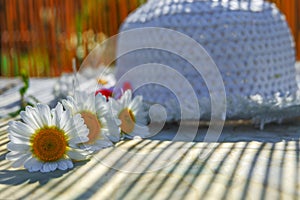 Women`s hat and daisies lying on the table. Background blur