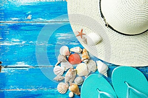 Women`s Hat Slippers Various Kinds of Spiral Flat Sea Shells Red Star Fish on Aged Plank Wood Blue Background. Summer Vacation