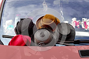 Women's hats are for sale on a windshield of a car