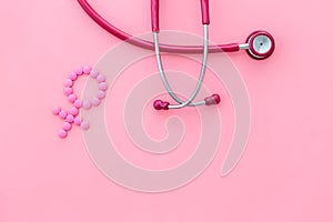 Women`s Health issues. Medical concept with Venus sign and stethoscope on pink background top-down copy space