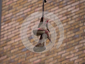 Women`s high heeled shoes dangling from a telephone wire