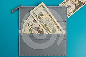 Women`s leather. Gray womens wallet with banknotes wallet studio image. Dollar bills in a wallet