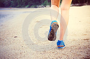 Women's legs running or walking along the beach.