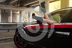 Women's legs sticking out of car window