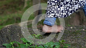 Women\'s legs walking on the Large Roots of a Tree