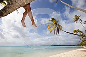 Women's legs on white sand beach