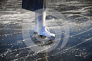 Women& x27;s legs in white skates on an outdoor ice rink. ... People, winter sport and leisure concept.