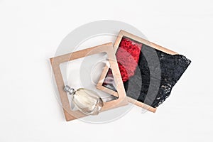 Women`s lingerie. Red and black lace bikini panties in paper box and glass bottle perfume