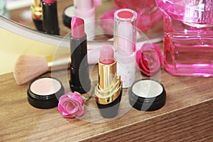 Women`s makeup cosmetics, pink lipstick and light eye shadow