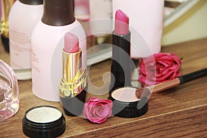 Women`s makeup cosmetics, pink lipstick and light eye shadow