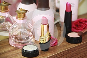 Women`s makeup cosmetics, pink lipstick and light eye shadow