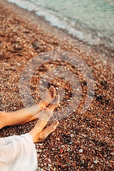 Women`s and men`s feet in the sand