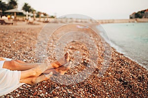 Women`s and men`s feet in the sand