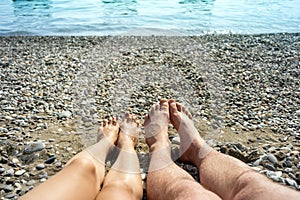 Women`s and men`s feet on beach