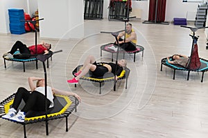 Women's and men's group on a sports trampoline, fitness training, healthy life - a concept trampoline group