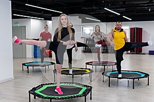 Women's and men's group on a sports trampoline, fitness training, healthy life - a concept trampoline group