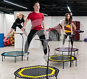 Women's and men's group on a sports trampoline, fitness training, healthy life - a concept trampoline group