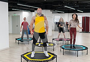 Women's and men's group on a sports trampoline, fitness training, healthy life - a concept trampoline group