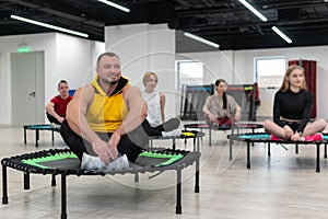 Women's and men's group on a sports trampoline, fitness training, healthy life - a concept trampoline group