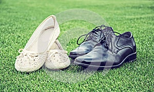 Women`s and men`s wedding shoes on grass