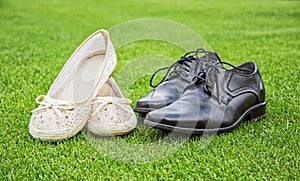 Women`s and men`s wedding shoes on the green grass