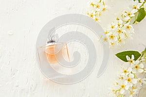 Women`s perfume in beautiful bottle and flowers on white background. Flat lay tools and accessories for woman