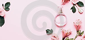 Women`s perfume bottle and roses flowers on pink background. Banner format with copy space