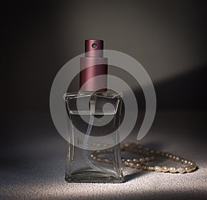 Women's perfume and string of pearls