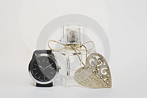 Women's perfume on a white background with a heart and a clock. Time to give gifts